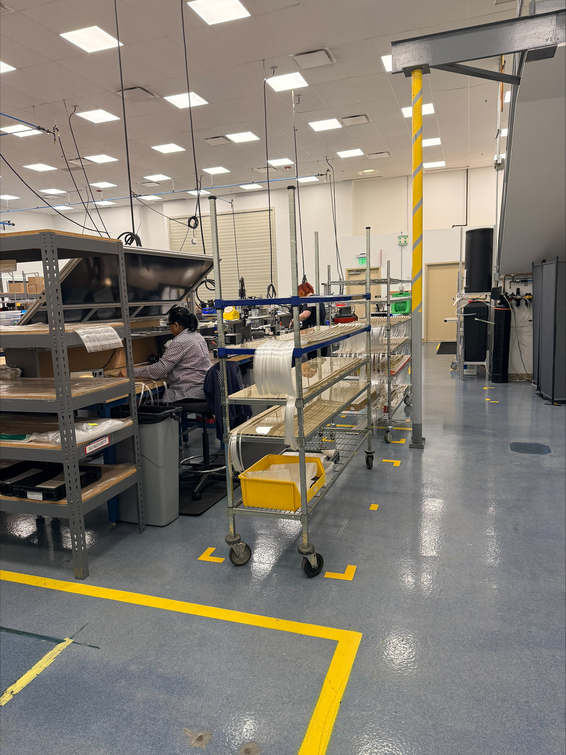Manufacturing team reviewing medical device components and global supply chain planning in a cleanroom